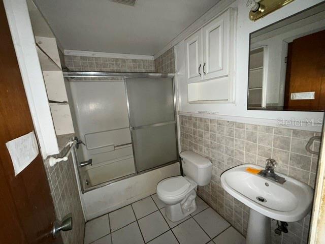 A bathroom features a pedestal sink, a toilet, and a shower-tub combination with sliding doors — 1050 BEACH LANE, WINTER HAVEN, FL