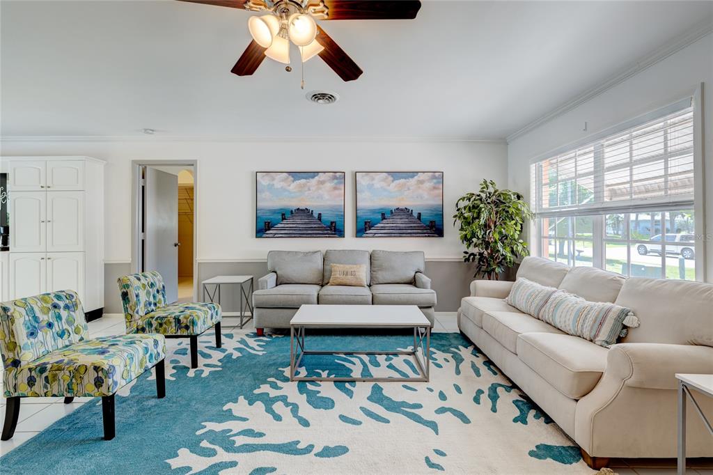 A living room features a blue patterned rug, two sofas, two armchairs, and wall art — 231 CADDY ROAD, ROTONDA WEST, FL