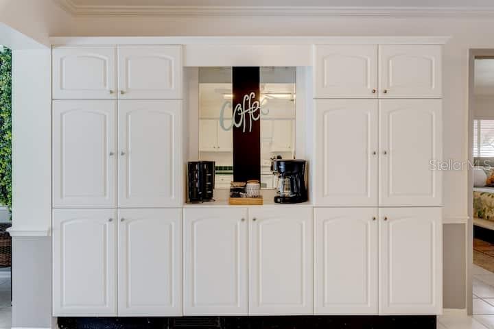 A white built-in coffee station features cabinet storage and a mirrored backsplash — 231 CADDY ROAD, ROTONDA WEST, FL