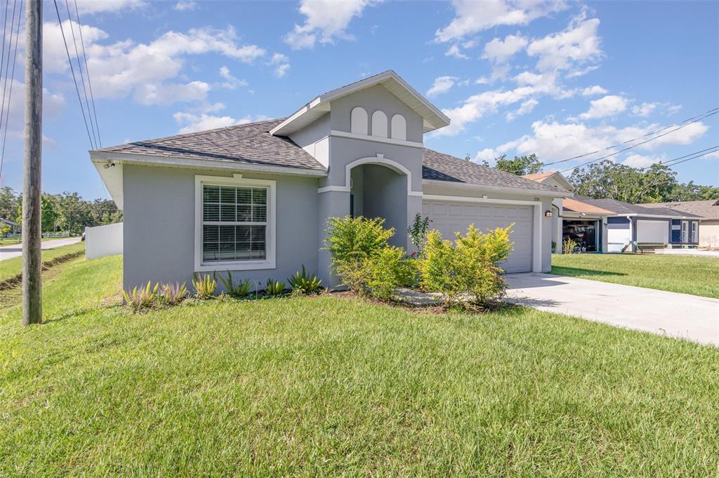 A single-story gray house with a two-car garage and a front lawn under a blue sky — 1534 PINE STREET, ORLANDO, FL