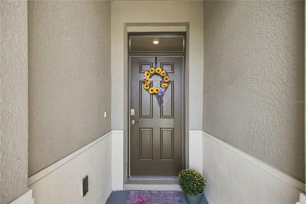 A front entryway features a dark brown door with a sunflower wreath and a transom window — 6457 SW 89TH LOOP, OCALA, FL