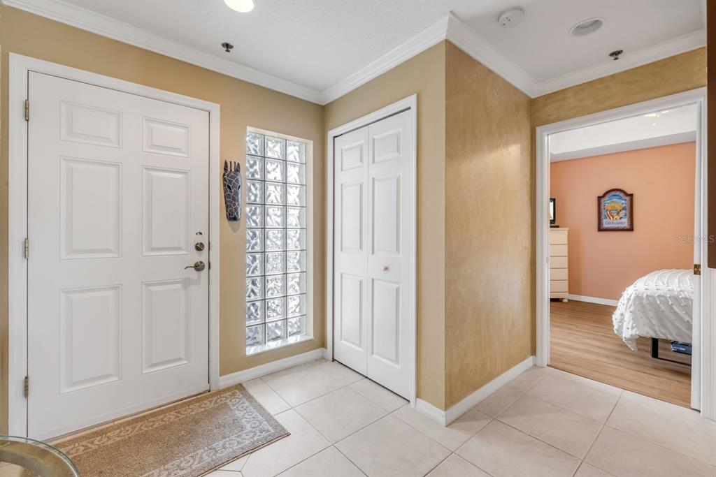 An entryway features a white front door, a glass block window, and a tiled floor — 5300 S ATLANTIC AVENUE UNIT 2-502, NEW SMYRNA BEACH, FL