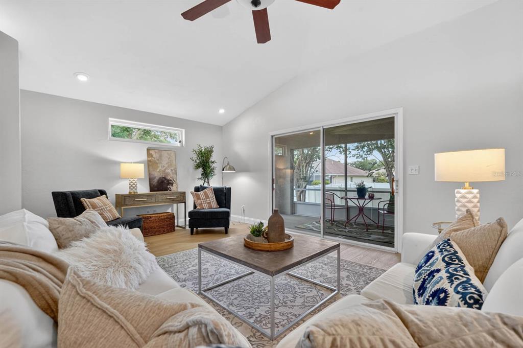 A tiled hallway leads to a living area with white walls and light wood flooring — 129 GREY DAPPLE WAY, ORMOND BEACH, FL