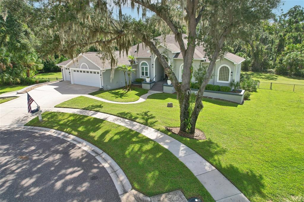 A single-story house with a gray exterior, a two-car garage, and a large front yard — 5207 MERION RD, VALRICO, FL