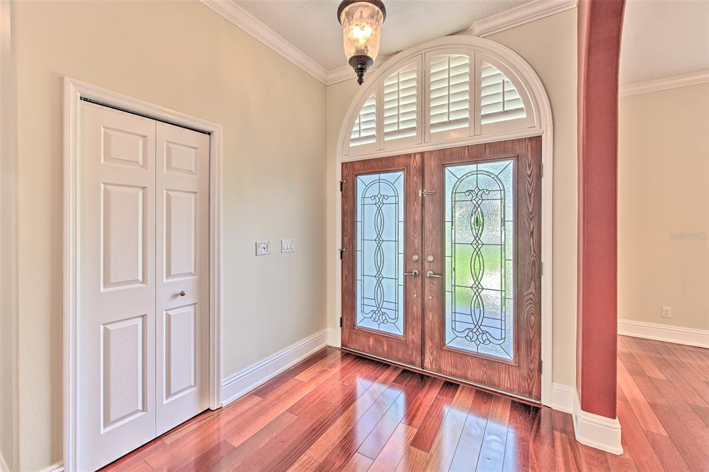 An entryway features hardwood floors, a white closet door, and double doors with glass inserts — 5207 MERION RD, VALRICO, FL