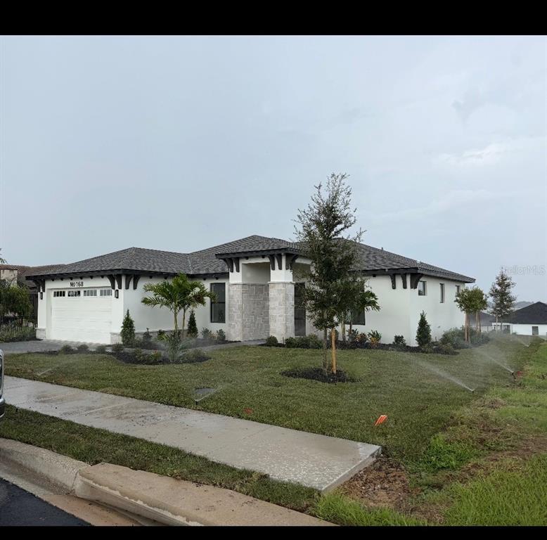 This is a rendering of a single-story house with a white stucco facade and garage — 168 FRINGE TREE, LAKE ALFRED, FL