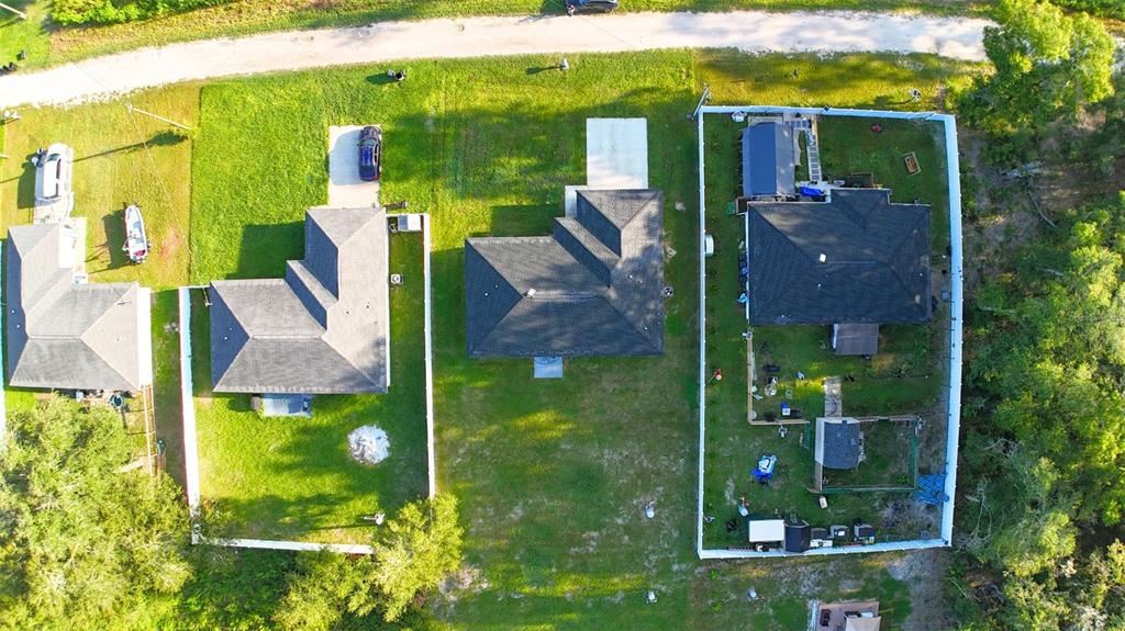 An open-concept living area features vaulted ceilings, gray wood-look flooring, and a kitchen island — 13264 SW 111TH LANE, DUNNELLON, FL