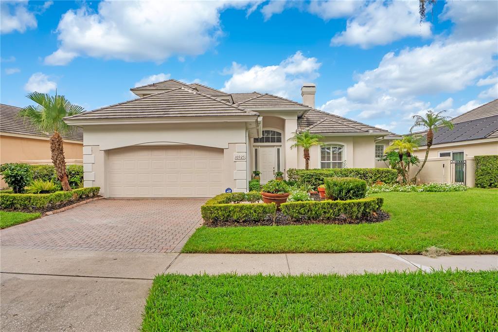 A single-story house with a beige exterior, a tiled roof, and a two-car garage — 10925 WOODCHASE CIRCLE, ORLANDO, FL