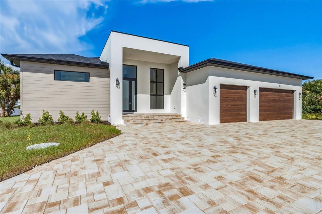 An infinity pool and spa overlook a lake under a blue sky with clouds — 44 SUNFLOWER DRIVE, PLACIDA, FL