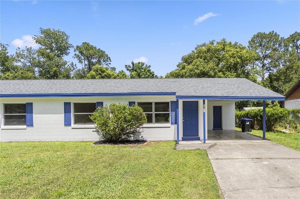 A single-story white house with blue shutters, a blue front door, and a carport — 1921 BONNEVILLE DRIVE, ORLANDO, FL