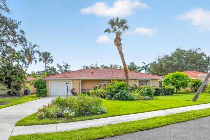 A single-story house with a red tile roof, a garage, and a palm tree — 122 49TH COURT E, PALMETTO, FL