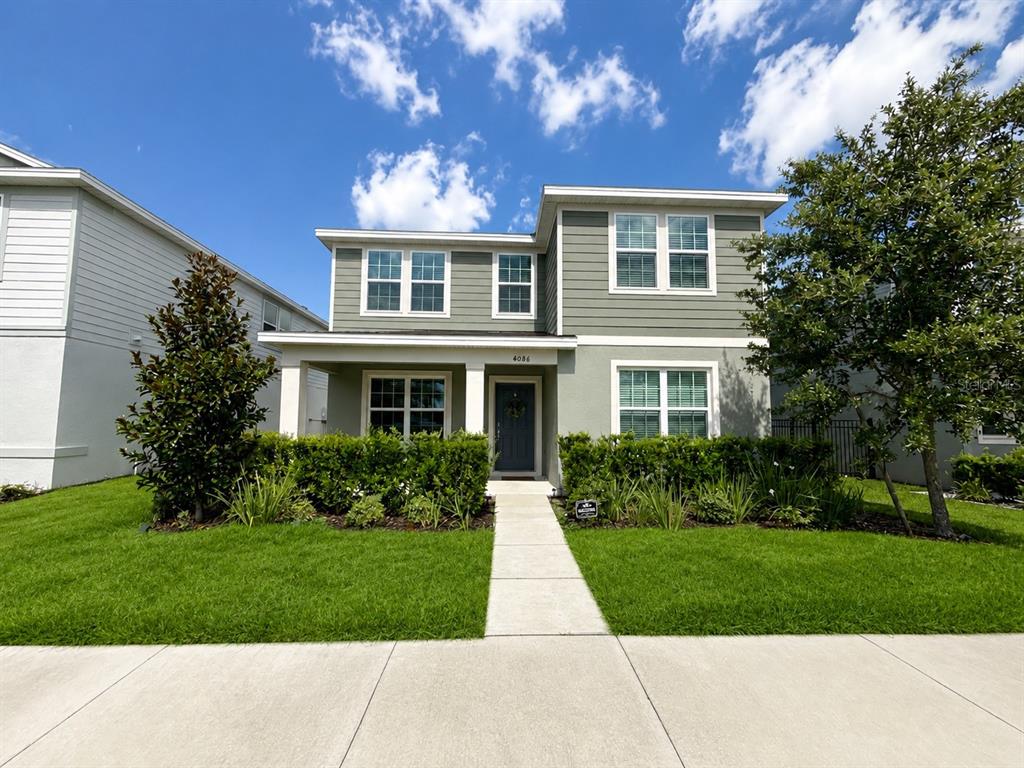 A two-story house with green siding, a front porch, and a concrete walkway — 4086 LUSH VIEW DRIVE, APOPKA, FL