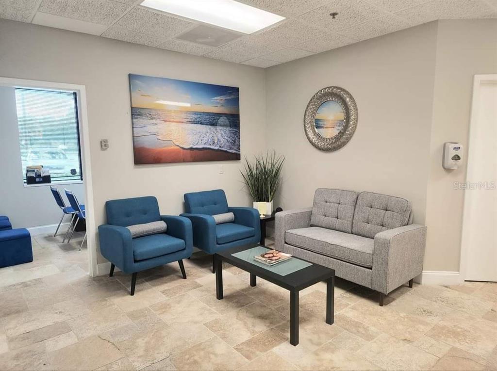 A waiting room features two blue armchairs, a gray loveseat, and a coffee table — 2500 W LAKE MARY BOULEVARD UNIT 107 D, LAKE MARY, FL