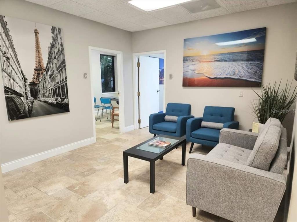 A waiting room features tile floors, two blue armchairs, a gray sofa, and wall art — 2500 W LAKE MARY BOULEVARD UNIT 107 D, LAKE MARY, FL