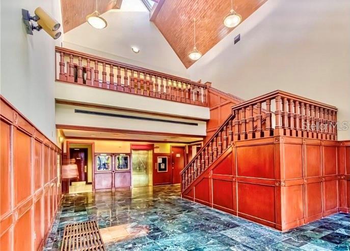 A grand lobby features wood-paneled walls, a staircase, and a high vaulted ceiling — 2500 W LAKE MARY BOULEVARD UNIT 107 D, LAKE MARY, FL