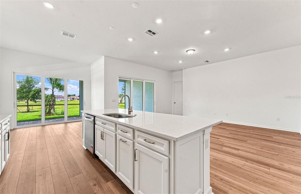 A living room features a blue geometric accent wall, a television, and a sectional sofa — 9452 DAYLIGHT DRIVE, PARRISH, FL