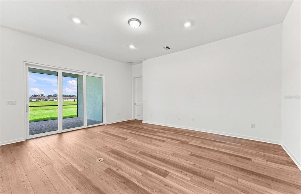 A dining room features a wooden table, upholstered chairs, a modern glass chandelier, and blue walls — 9452 DAYLIGHT DRIVE, PARRISH, FL
