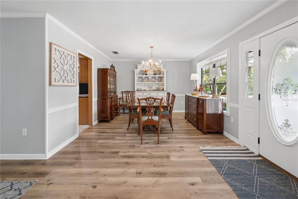 A dining room with light gray walls, wood-look flooring, a hutch, and a chandelier — 10283 RIVER WOOD DRIVE, LIVE OAK, FL