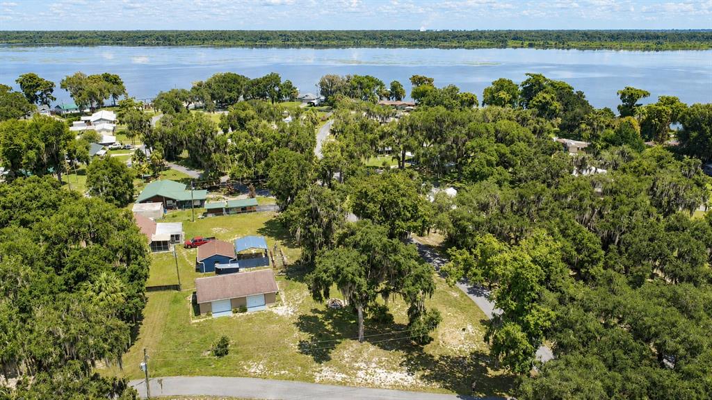 An aerial view shows a residential property with a detached garage near a large lake — 1055 CR-453, LAKE PANASOFFKEE, FL