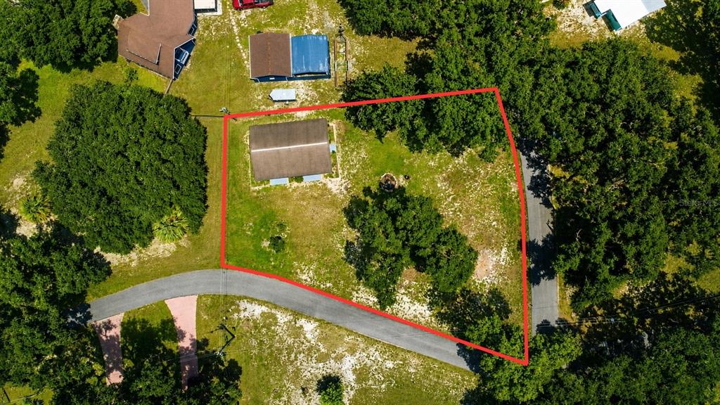 An aerial view shows a rectangular building on a wooded lot outlined in red — 1055 CR-453, LAKE PANASOFFKEE, FL