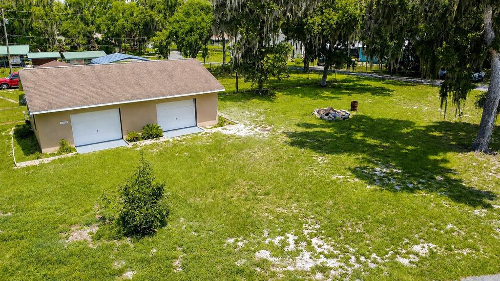 An aerial view shows a detached two-car garage on a grassy lot with trees — 1055 CR-453, LAKE PANASOFFKEE, FL
