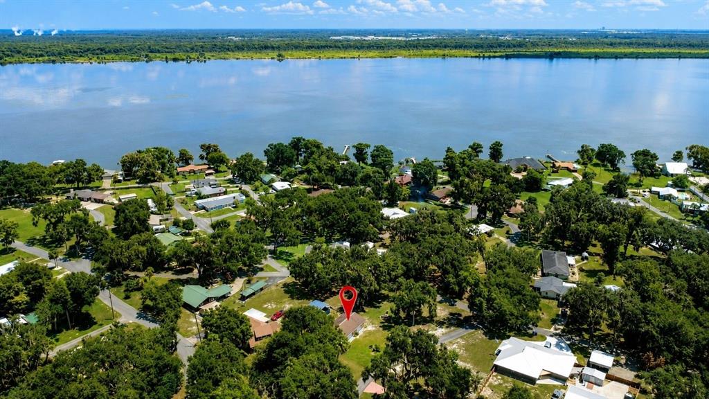 An aerial view shows a house marked with a red pin in a wooded neighborhood — 1055 CR-453, LAKE PANASOFFKEE, FL