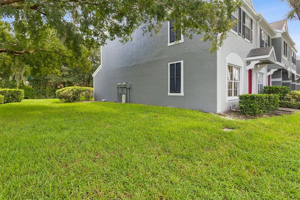 A gray two-story townhouse exterior with a green lawn and a large tree — 279 COUNTRYSIDE KEY BOULEVARD, OLDSMAR, FL