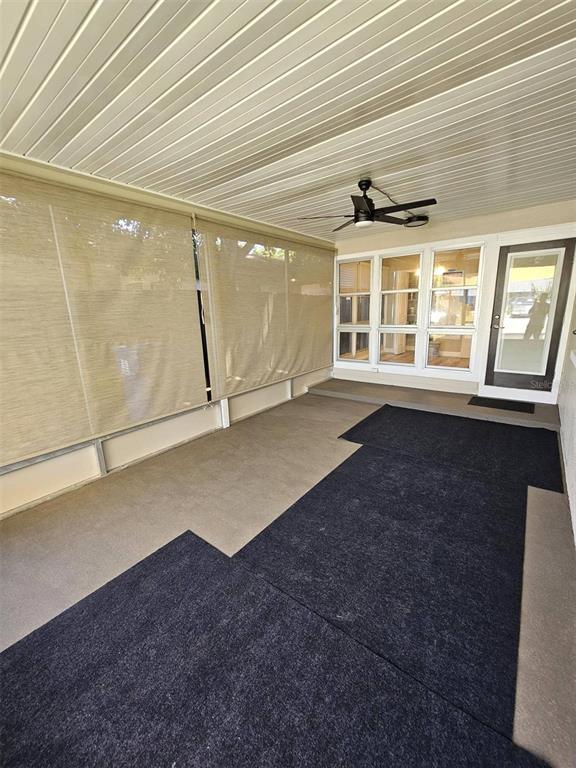 A covered patio features a ceiling fan, beige privacy shades, and dark outdoor carpeting — 3113 25TH STREET N, ST PETERSBURG, FL