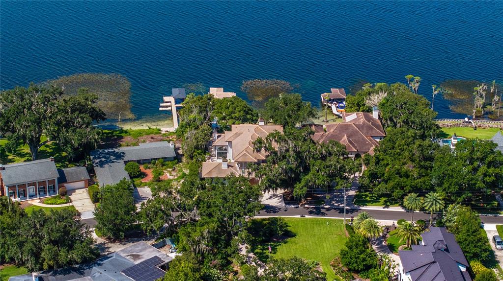 An aerial view shows several large houses situated along the shore of a lake — 800 W 2ND AVENUE, WINDERMERE, FL