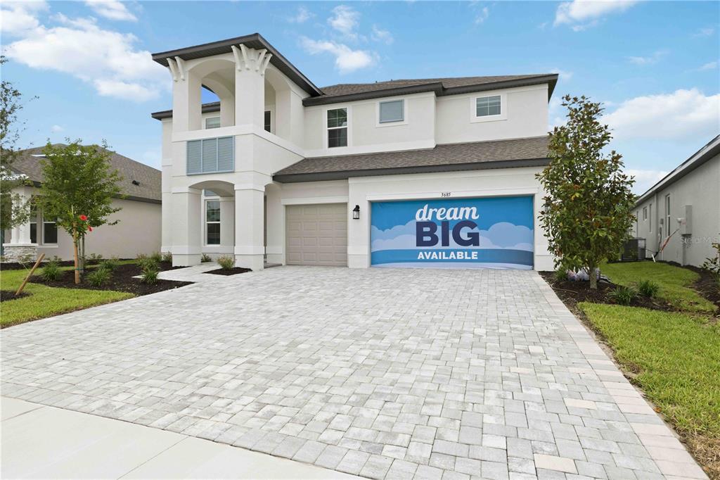 A two-story house with a white exterior, a paver driveway, and a garage door banner — 3685 142ND TERRACE E, PARRISH, FL