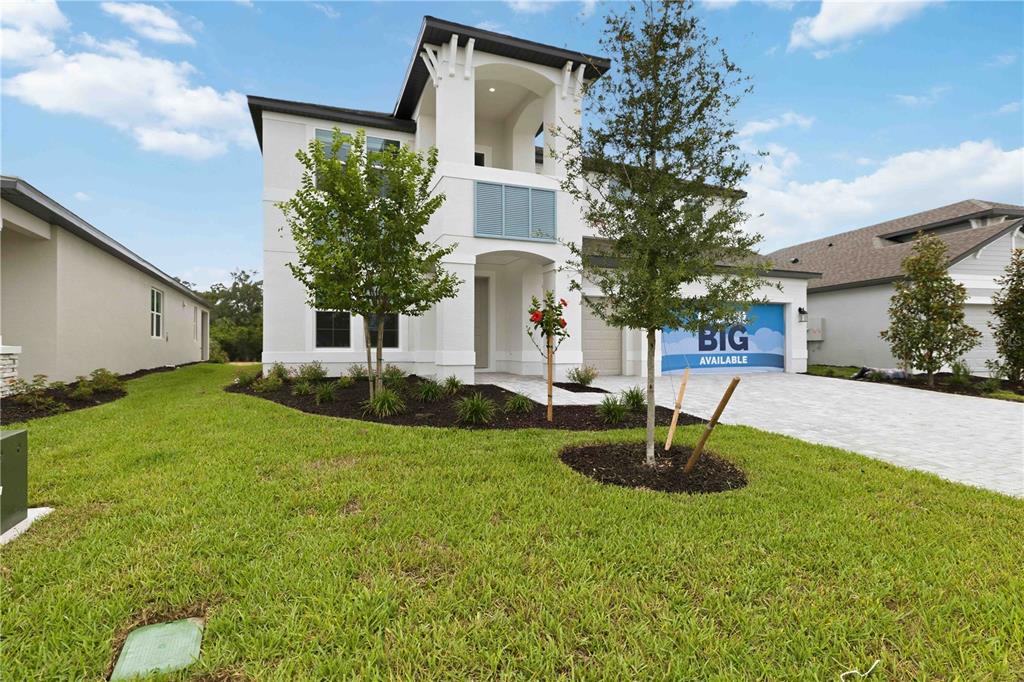 A two-story white house with a paved driveway and a blue garage door sign — 3685 142ND TERRACE E, PARRISH, FL