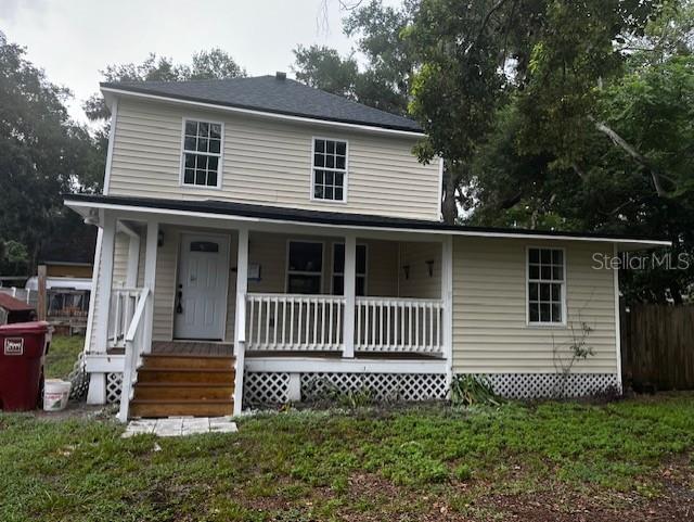 A two-story house with light-colored siding, a front porch, and a white railing — 1702 N GORDON STREET, PLANT CITY, FL