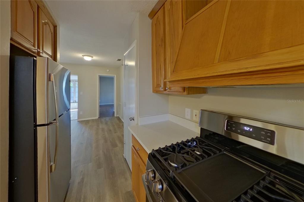 A kitchen with wood cabinets, stainless steel appliances, and light-colored countertops — 2022 68TH AVENUE S, ST PETERSBURG, FL
