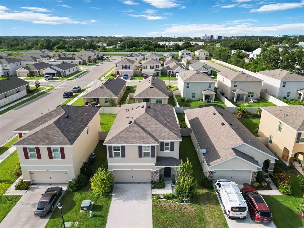An aerial view shows three suburban houses with driveways and lawns in a residential neighborhood — 5904 SILVER SAGE WAY, SARASOTA, FL