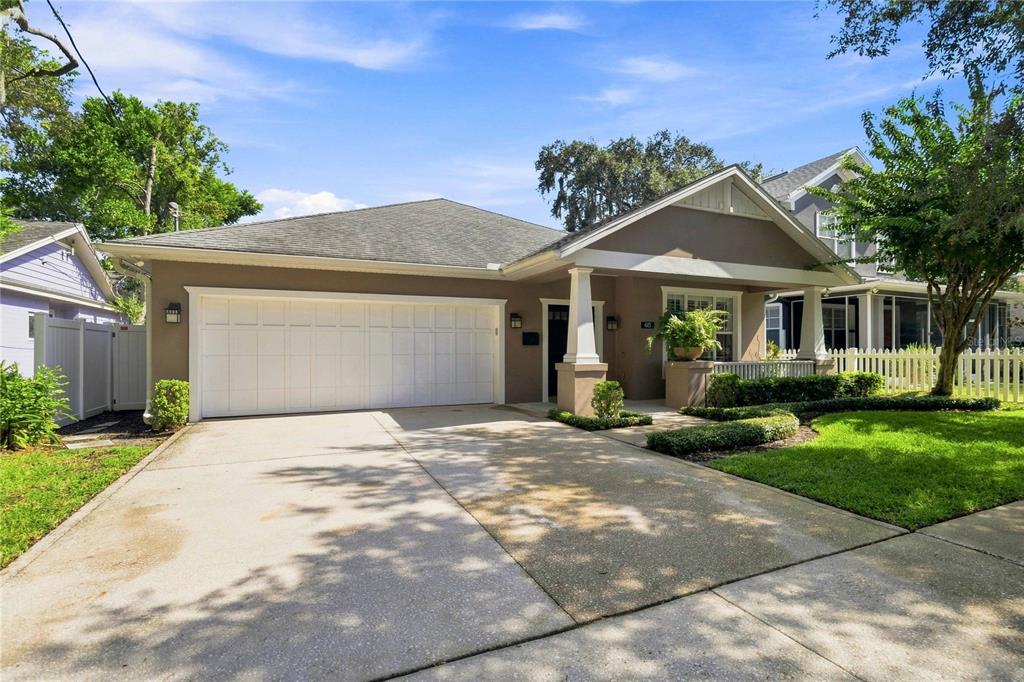 A single-story house with a two-car garage, a covered front porch, and a concrete driveway — 615 E KALEY STREET, ORLANDO, FL