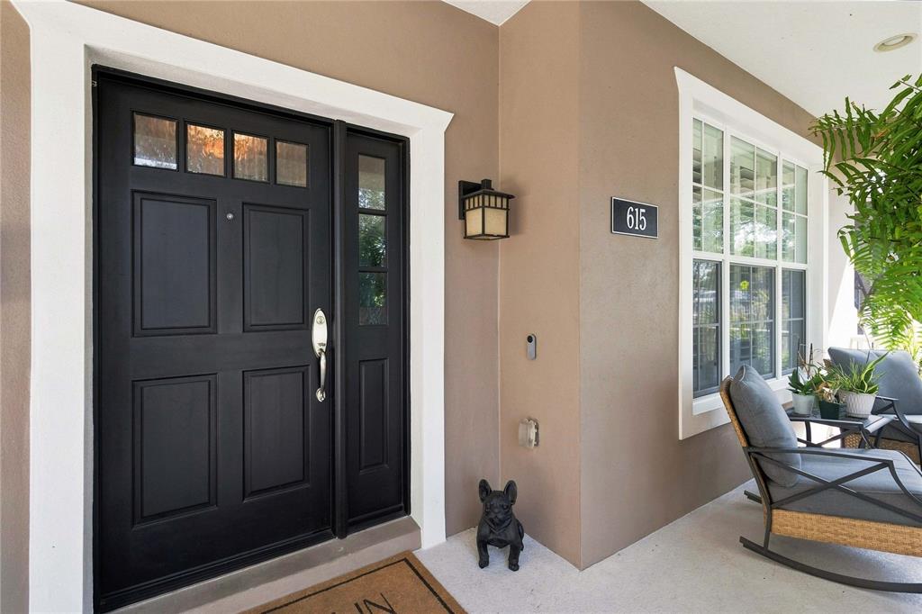 A black front door with a sidelight and a house number sign on a porch — 615 E KALEY STREET, ORLANDO, FL