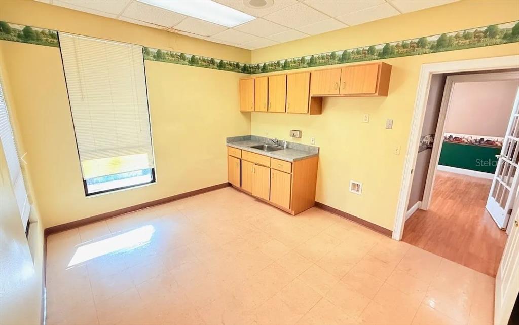 A kitchen with light wood cabinets, a sink, and yellow walls with a decorative border — 9401 SW HIGHWAY 200 UNIT 600, OCALA, FL