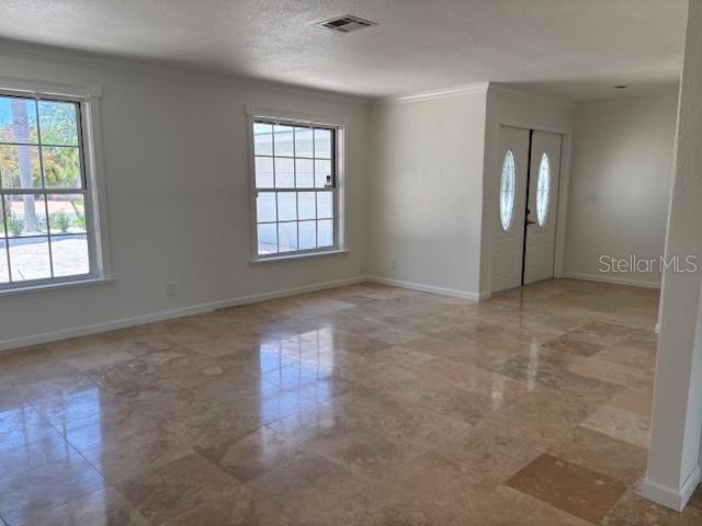 A bright room features light-colored walls, large windows, and polished stone tile flooring — 12055 4TH STREET E, TREASURE ISLAND, FL