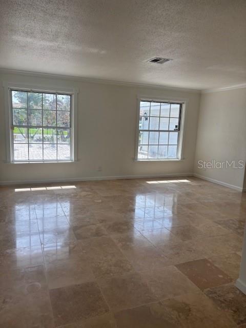 A room with light-colored walls, two windows, and polished stone tile flooring — 12055 4TH STREET E, TREASURE ISLAND, FL