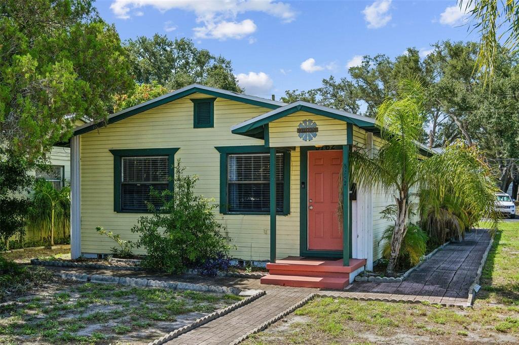 A yellow single-story house with a red front door and a brick walkway — 5762 2ND AVENUE N, ST PETERSBURG, FL
