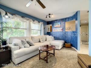 A living room features a large white sectional sofa, a wooden coffee table, and blue walls — 205 RITA BOULEVARD, MELBOURNE BEACH, FL