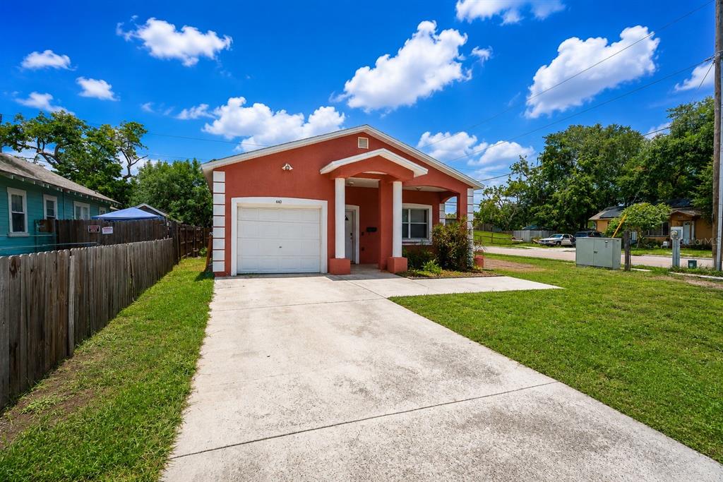 A single-story red house with a white garage door and a covered front porch — 1440 PRESCOTT STREET S, ST PETERSBURG, FL