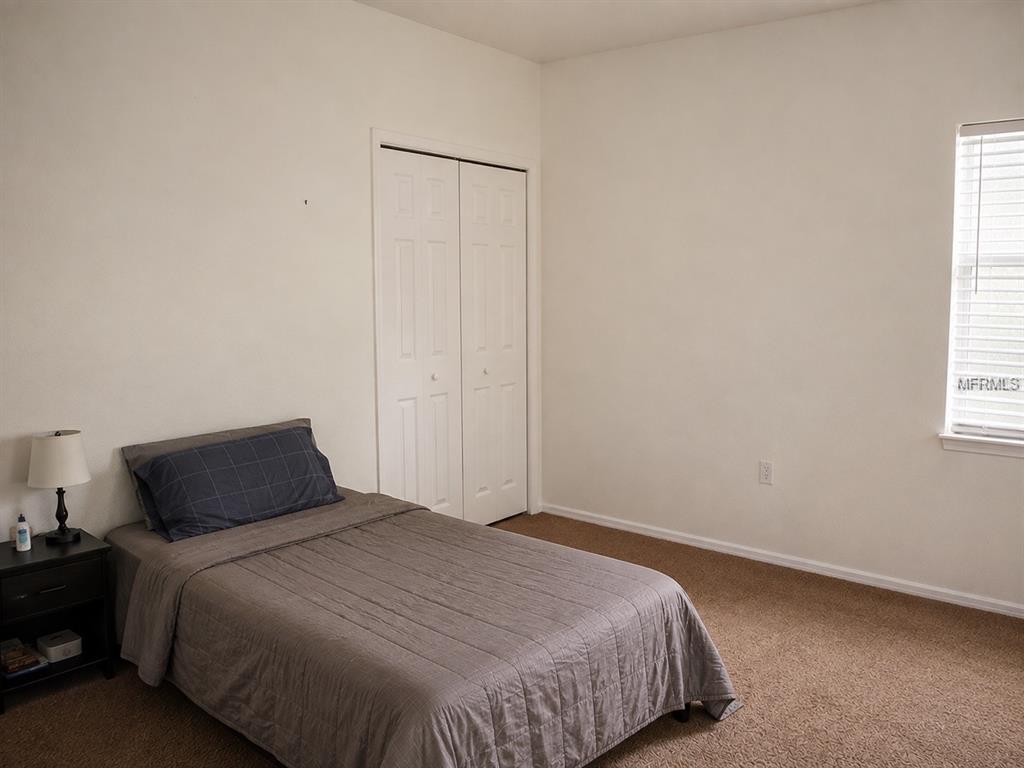 A bedroom features a single bed, a nightstand with a lamp, and a white closet — 1440 PRESCOTT STREET S, ST PETERSBURG, FL