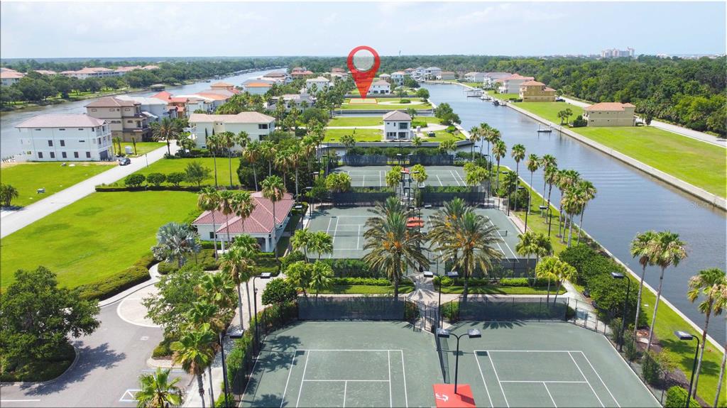 An aerial view of a residential community featuring multiple tennis courts and a canal — 8 SCHOONER CIRCLE, PALM COAST, FL