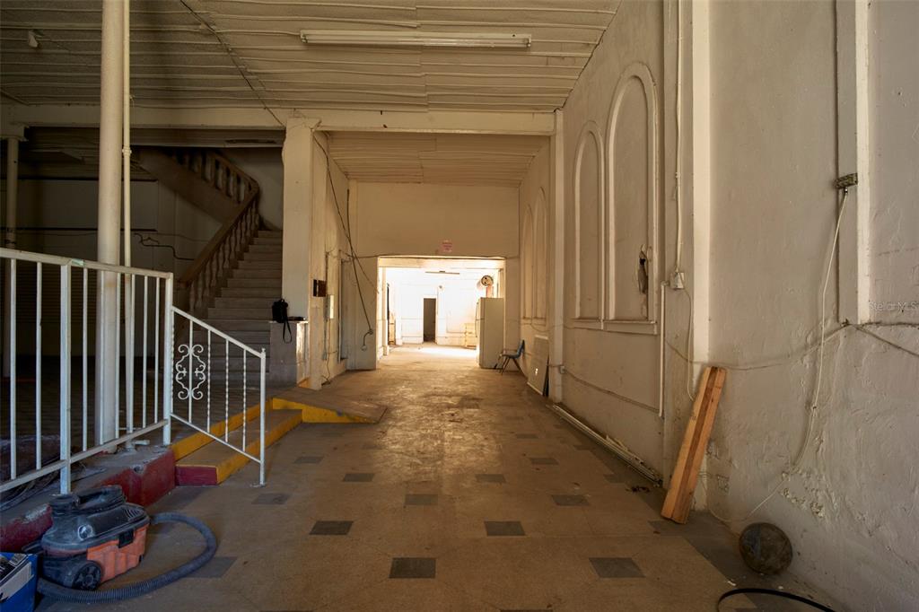 An interior view of a vacant, unfinished commercial space with a staircase and concrete flooring — 2001 N HOWARD AVENUE, TAMPA, FL