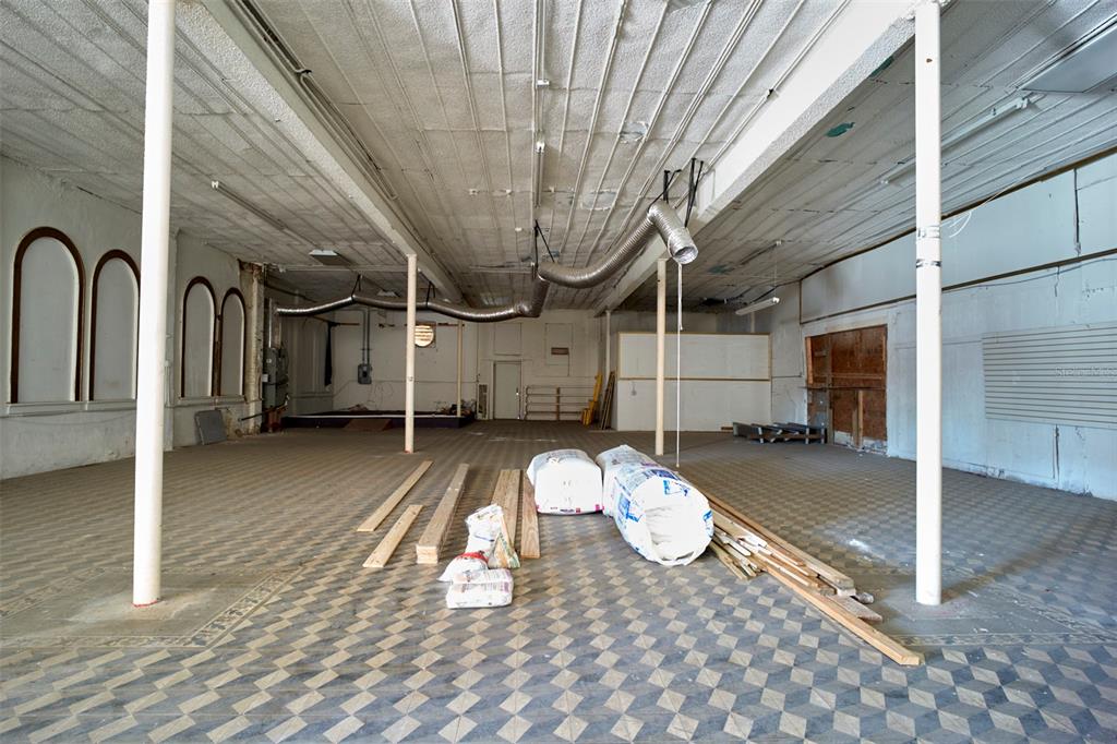 An empty commercial space features a checkered floor, white support columns, and exposed ceiling ductwork — 2001 N HOWARD AVENUE, TAMPA, FL