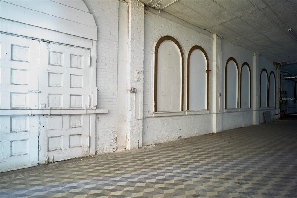 An interior view of a room with white brick walls, arched wall panels, and patterned flooring — 2001 N HOWARD AVENUE, TAMPA, FL