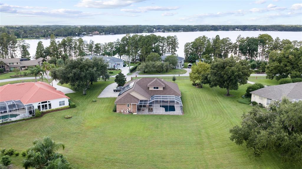 A single-story brick house with a hip roof and a front lawn under a blue sky — 17825 SIMMS ROAD, ODESSA, FL
