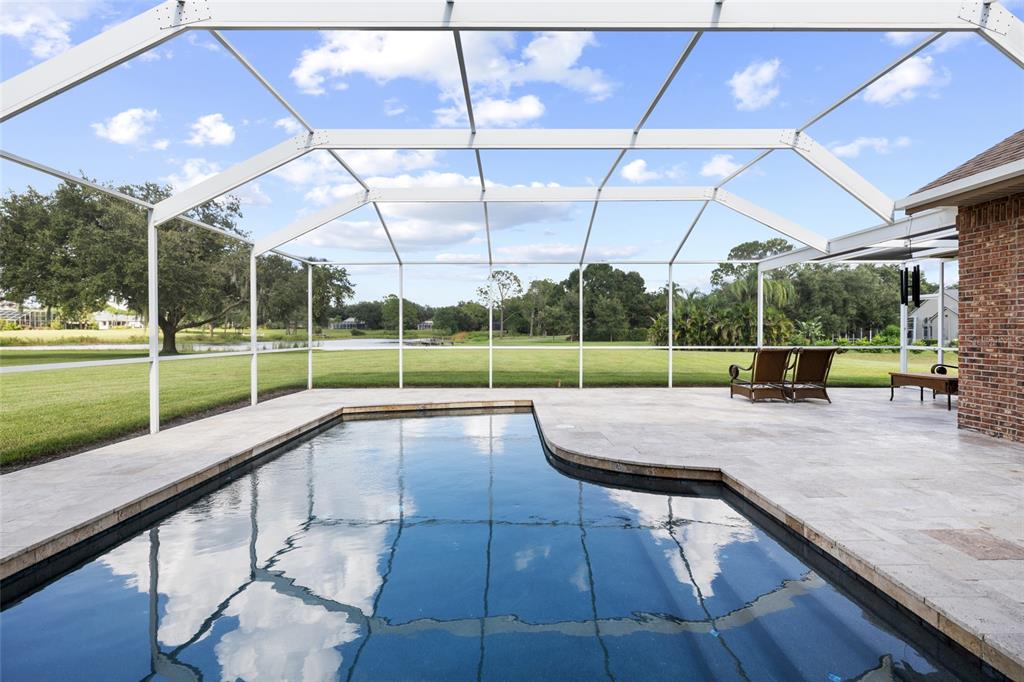 A single-story brick house with a hip roof and a front lawn at sunset — 17825 SIMMS ROAD, ODESSA, FL