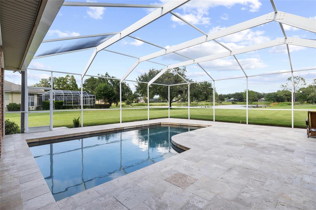 A brick house exterior features a covered entryway, a concrete walkway, and a landscaped lawn — 17825 SIMMS ROAD, ODESSA, FL
